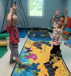 children doing sensory yoga with a dinosaur